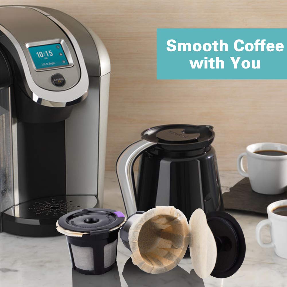 A sleek coffee maker sits on a marble counter with two cups of morning coffee nearby. In the foreground, there are two reusable Keurig cups and a collection of 300 unbleached paper filters compatible with Keurig 2.0 & 1.0 coffee makers by CAPMESSO, along with a black coffee carafe. A sign reads Smooth Coffee with You.